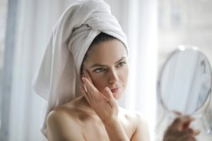 Frau trägt Retinol Serum auf Gesicht auf